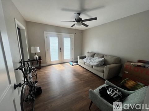A living room with a grey couch and a bicycle leaning against the wall.