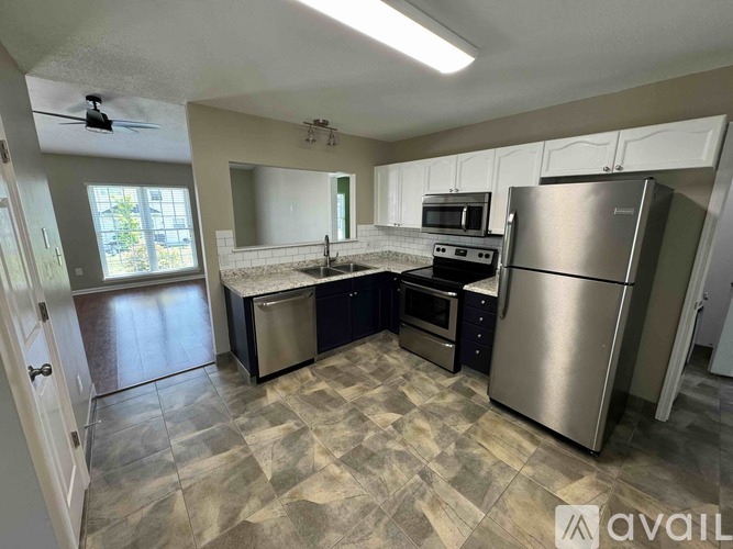 A kitchen with a refrigerator, oven, and microwave.