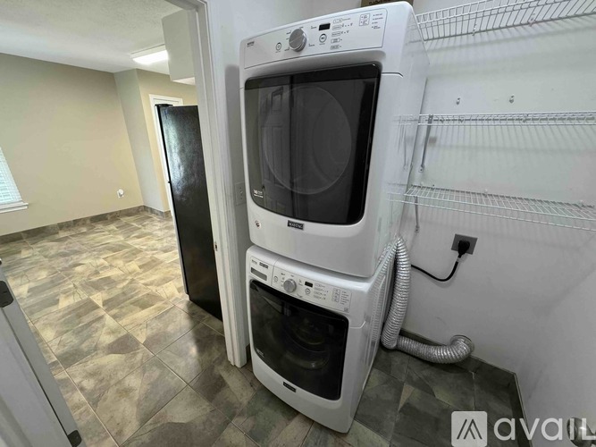 A white oven and microwave are in a kitchen with a black door.