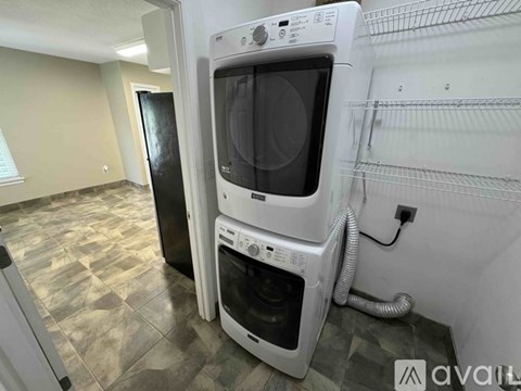 A white oven and microwave are in a kitchen with a black door.