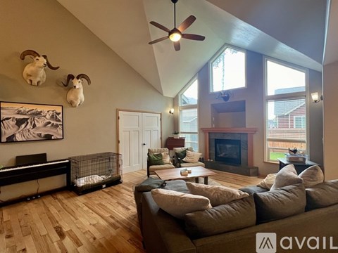 A living room with a couch, a fireplace, and a painting of a mountain scene on the wall.