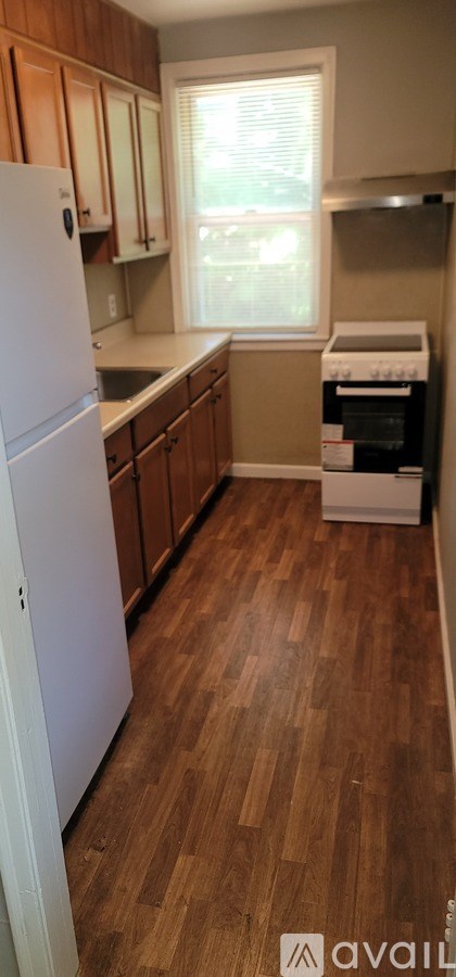 A kitchen with wooden floors and white appliances.