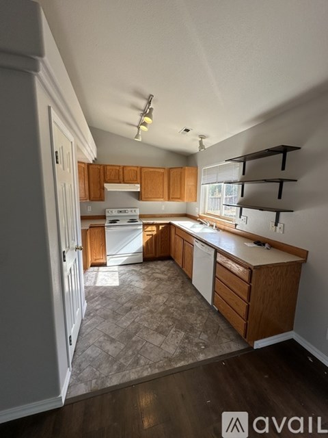 A kitchen with wooden cabinets and a white dishwasher.