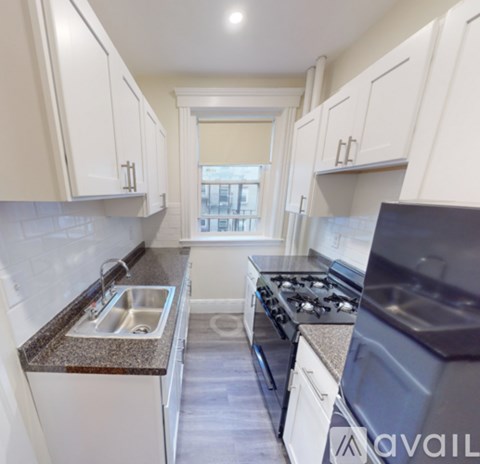 A kitchen with white cabinets and a black stove top oven.