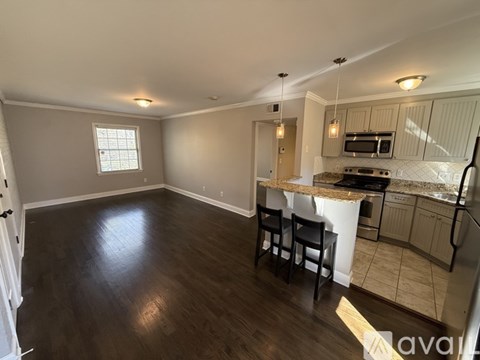 A kitchen with a dining table and chairs is visible.