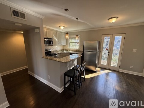 A kitchen with a refrigerator, stove, and microwave.