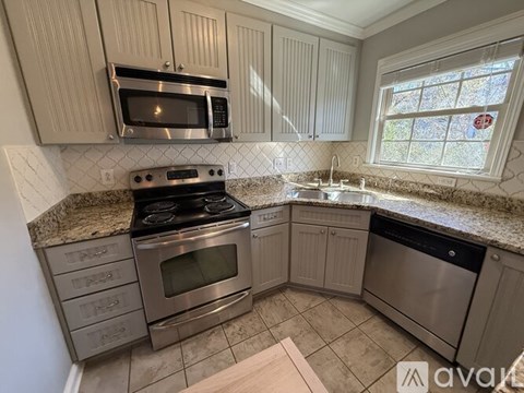 A kitchen with a stove top oven and microwave above it.