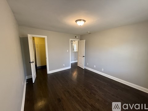 A spacious room with wooden floors and white walls.