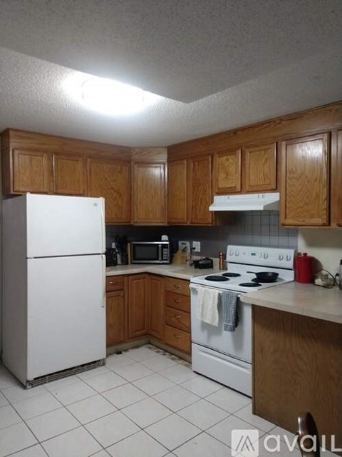 A kitchen with wooden cabinets and white appliances.