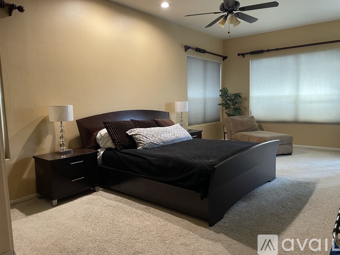 A bedroom with a large bed and a ceiling fan.