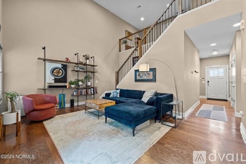 A living room with a blue couch and a staircase.
