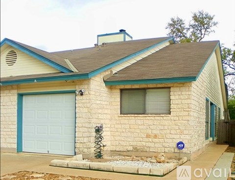 A house with a blue garage door and a stone exterior.