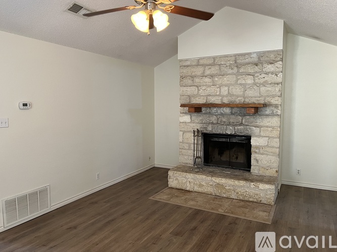 A room with a window covered by white blinds and wooden flooring.