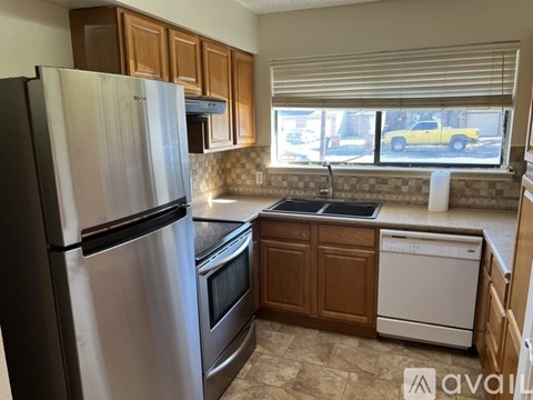 A kitchen with a black refrigerator and a white dishwasher.