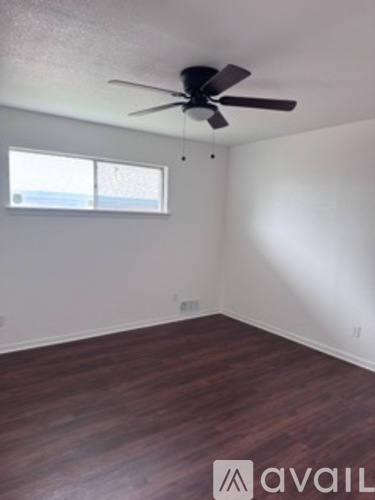 A room with a ceiling fan and a window.