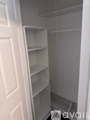 A white pantry with shelves and a door.