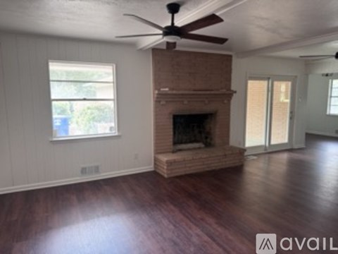 A living room with a fireplace and a ceiling fan.