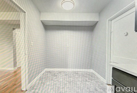 A room with a carpeted floor and a door on the left.