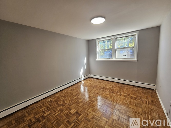 A room with wooden flooring and a window.