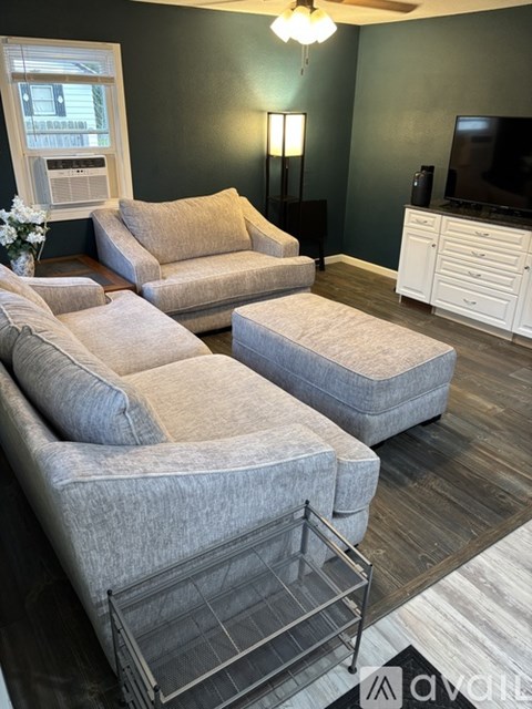 A living room with a grey sofa and a television.