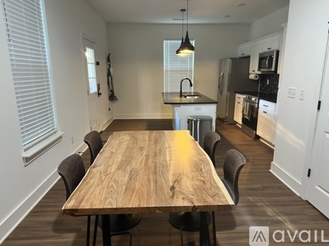 A modern kitchen with a wooden table and chairs.