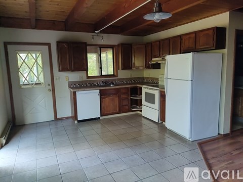 A kitchen with white appliances and wooden cabinets.