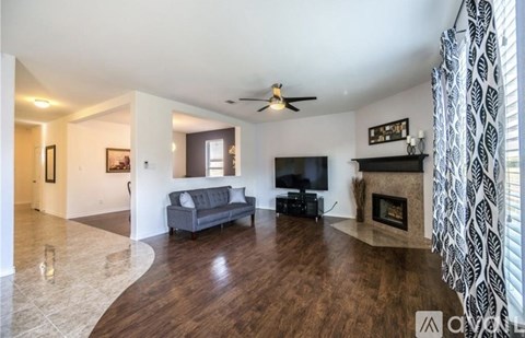 A living room with a grey couch and a fireplace.