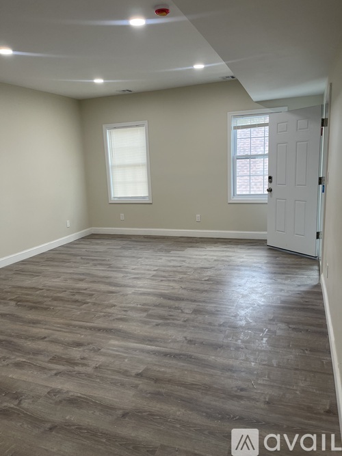 A room with a wooden floor and a white door.