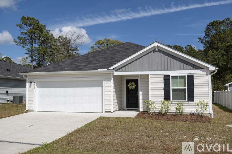 A house with a grey roof and a white garage door is for sale.