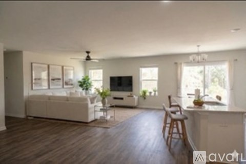 A living room with a white couch and a television.