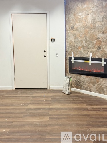 A room with a door and a fireplace.