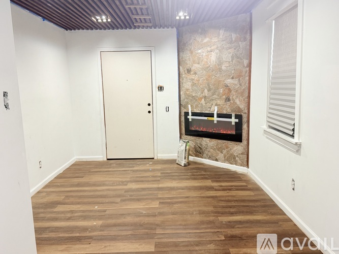 A room with a wooden floor and a stone wall.
