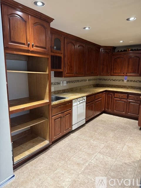 A kitchen with wooden cabinets and a white dishwasher.
