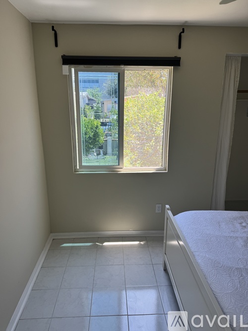A bedroom with a bed and a window with a view of the outside.