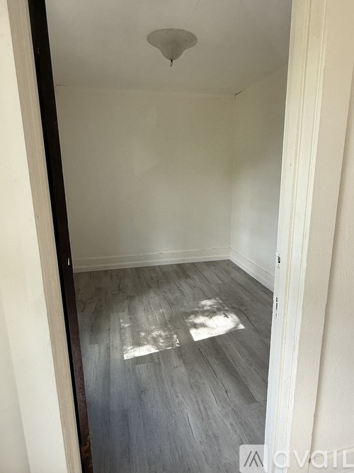 A room with a wooden floor and white walls.