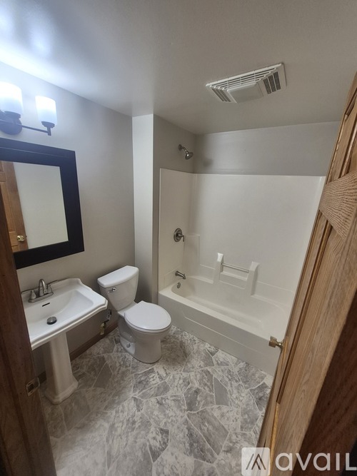 A bathroom with a toilet, sink, and bathtub.