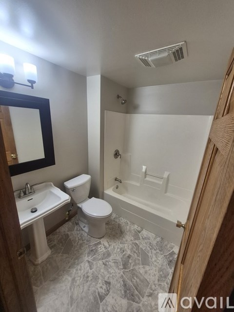 A bathroom with a toilet, sink, and bathtub.
