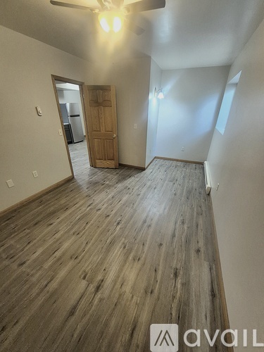 A room with wooden flooring and a ceiling fan.