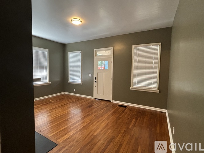 A room with wooden flooring and a white door.