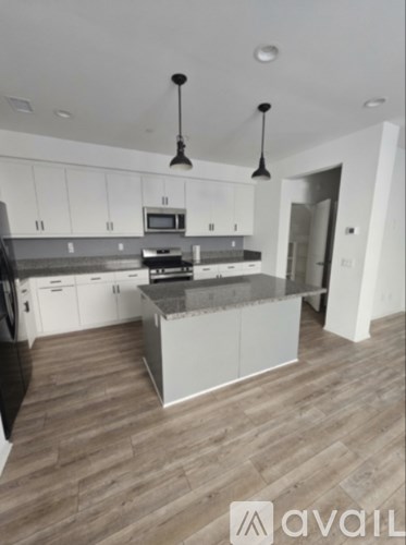 A kitchen with a refrigerator, microwave, oven, and sink.