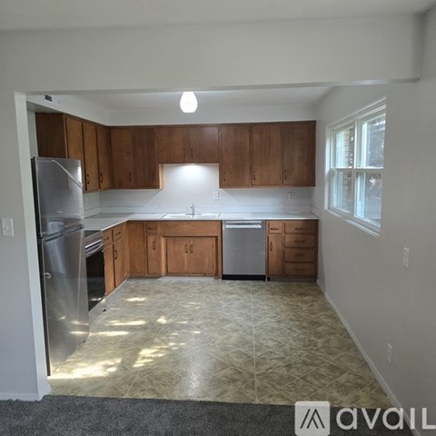 A kitchen with wooden cabinets and a refrigerator.
