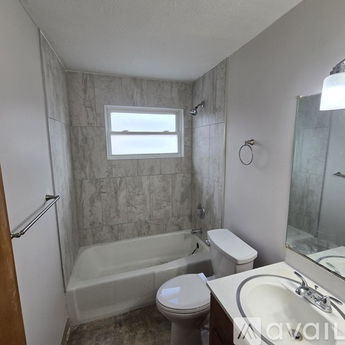 A bathroom with a tub, toilet, and sink.