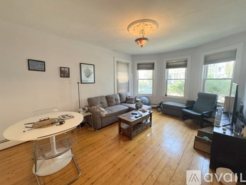 A living room with a white table and grey couches.