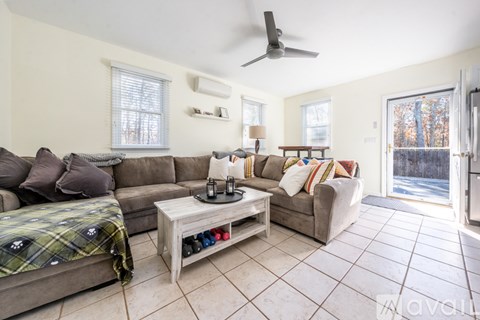 A living room with a grey couch and a wooden coffee table.