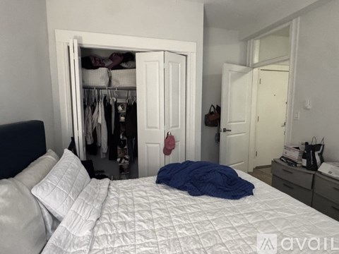 A bedroom with a bed, a closet, and a desk.