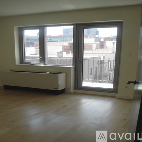 A room with a window and a door leading to a balcony.