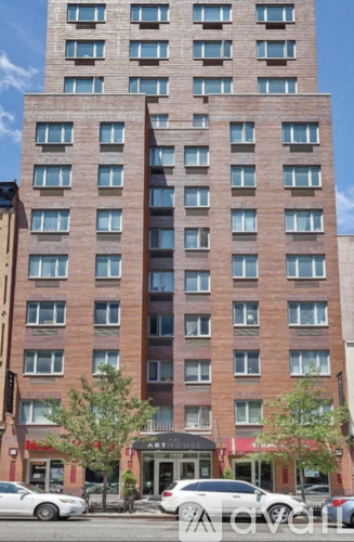 A tall building with a red brick facade and a black awning that reads "Artisan.".