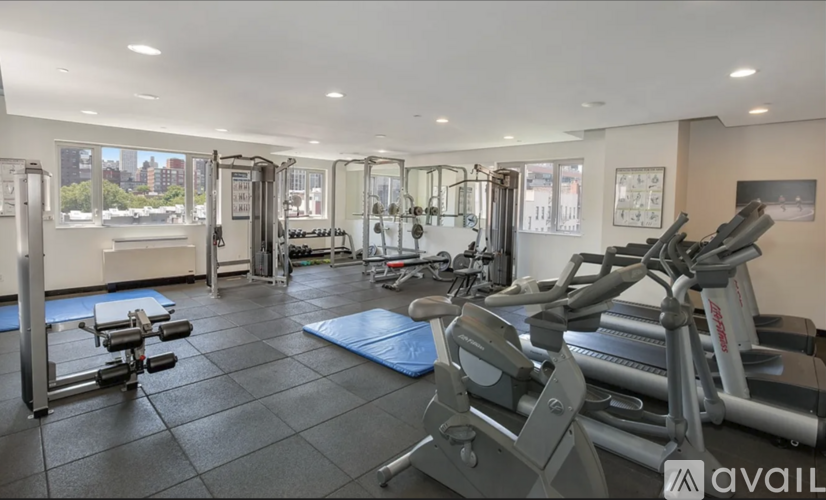 A gym with a variety of equipment including treadmills, weights, and exercise machines.