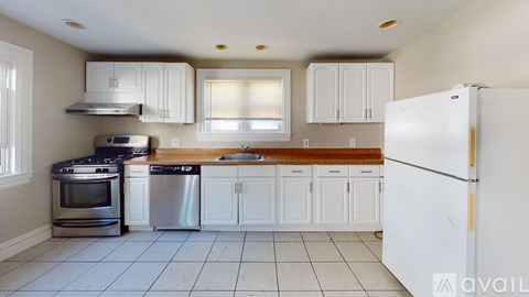 A kitchen with white cabinets and appliances.