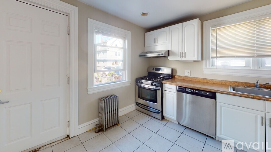 A kitchen with white cabinets and a stainless steel dishwasher.